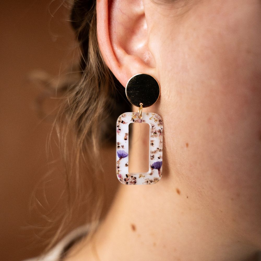 Rectangular resin statement earrings with pink erica and sea lavender flowers, gold plated brass disc studs and sterling silver posts.