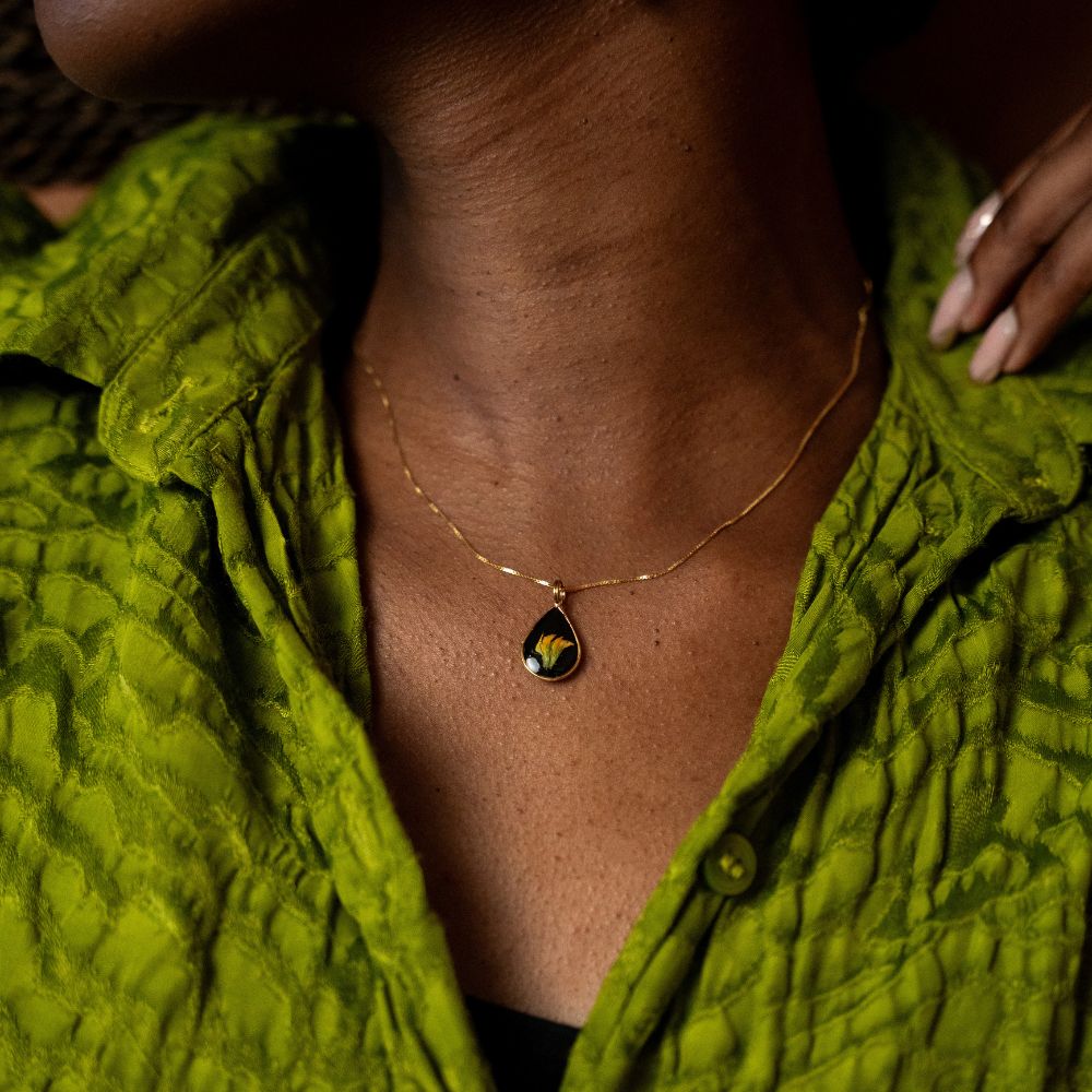 Gold teardrop pendant necklace with real wild pea flower from Cape Town set in resin on a gold plated sterling silver chain.