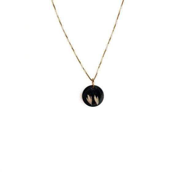 Gold plated sterling silver necklace with black resin pendant featuring real grass seeds from Cape Town.