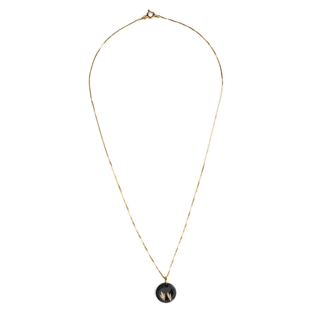 Gold plated sterling silver necklace with black resin pendant featuring real grass seeds from Cape Town.