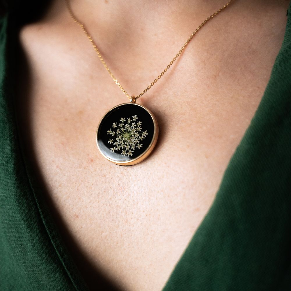 Gold round pendant necklace with real wild lace flowers from Germany set in resin on a gold plated sterling silver chain.