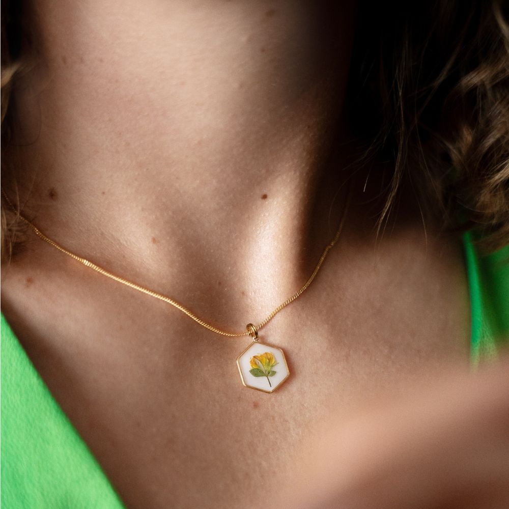 Hexagon gold plated necklace with real wild pea flower preserved in resin.