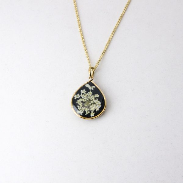Handmade gold pendant with delicate white lace flowers on black resin base