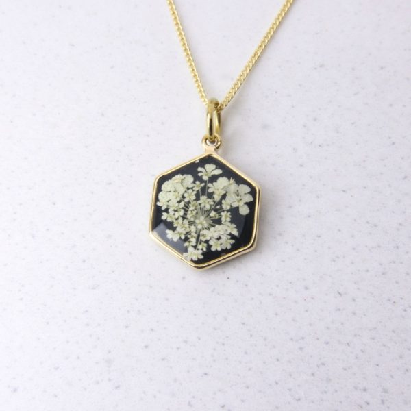 Gold hexagon pendant with wild lace flowers set in black resin.