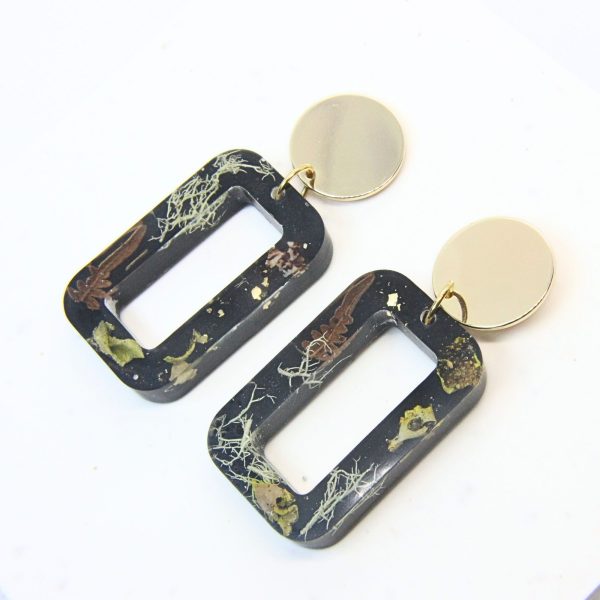 Black rectangular resin earrings with wild lichen, fern and moss inlay, gold plated brass disc tops and sterling silver studs.
