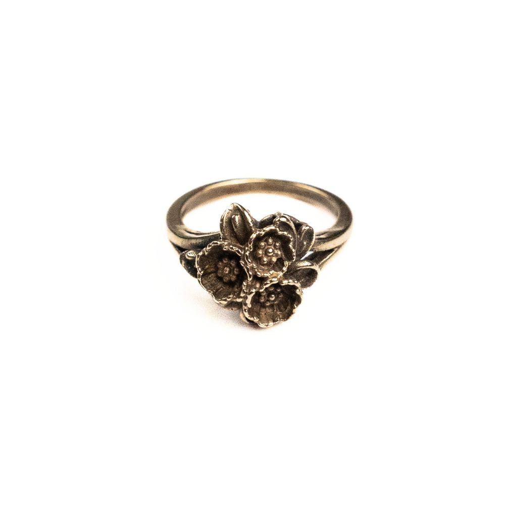 Brass ring featuring a sculpted cluster of small flowers.