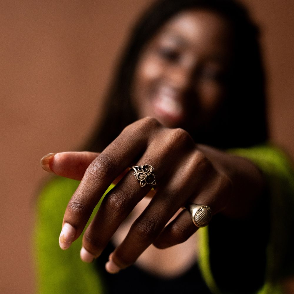 Brass ring featuring a sculpted cluster of small flowers.