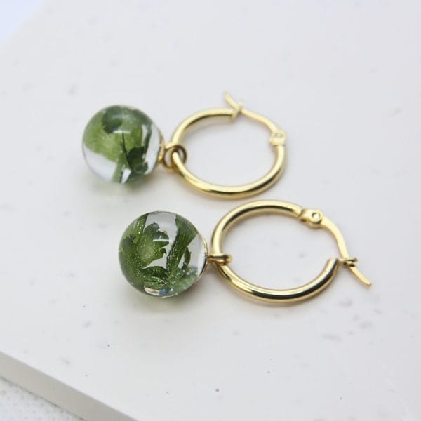 Clear resin globe hoop earring with preserved maidenhair fern, stainless steel hoop fitting.