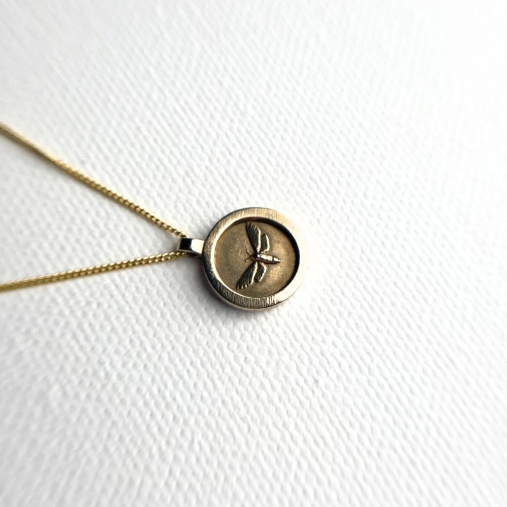 Small round brass moth pendant necklace on gold plated sterling silver chain, 15mm coin style design.