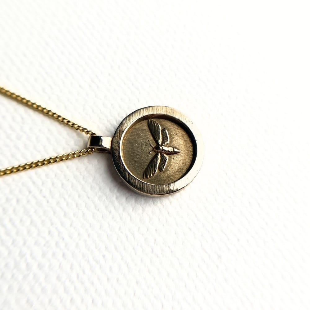 Small round brass moth pendant necklace on gold plated sterling silver chain, 15mm coin style design.