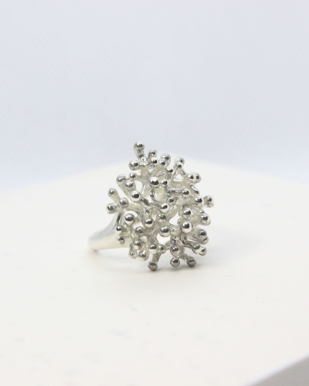 Sterling silver coral-inspired statement ring with clustered organic texture and polished finish.