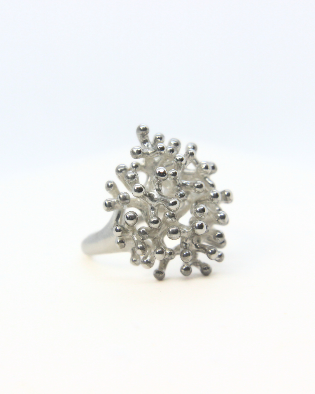 Sterling silver coral-inspired statement ring with clustered organic texture and polished finish.