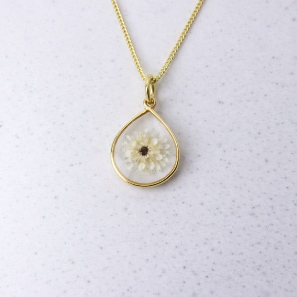 Gold teardrop pendant with a preserved white fynbos flower set in clear resin on a gold chain.